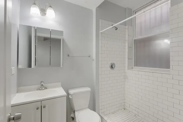 a bathroom with a toilet sink vanity and mirror