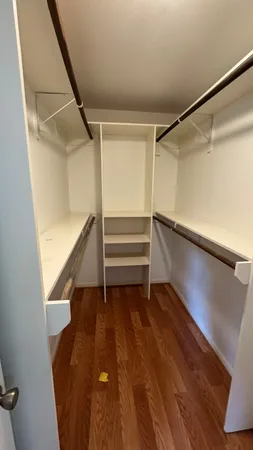 a view of an empty room with wooden floor and stairs