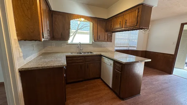 a kitchen with granite countertop a sink and a stove