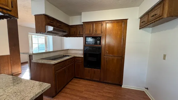 a kitchen with stainless steel appliances granite countertop a refrigerator and a stove
