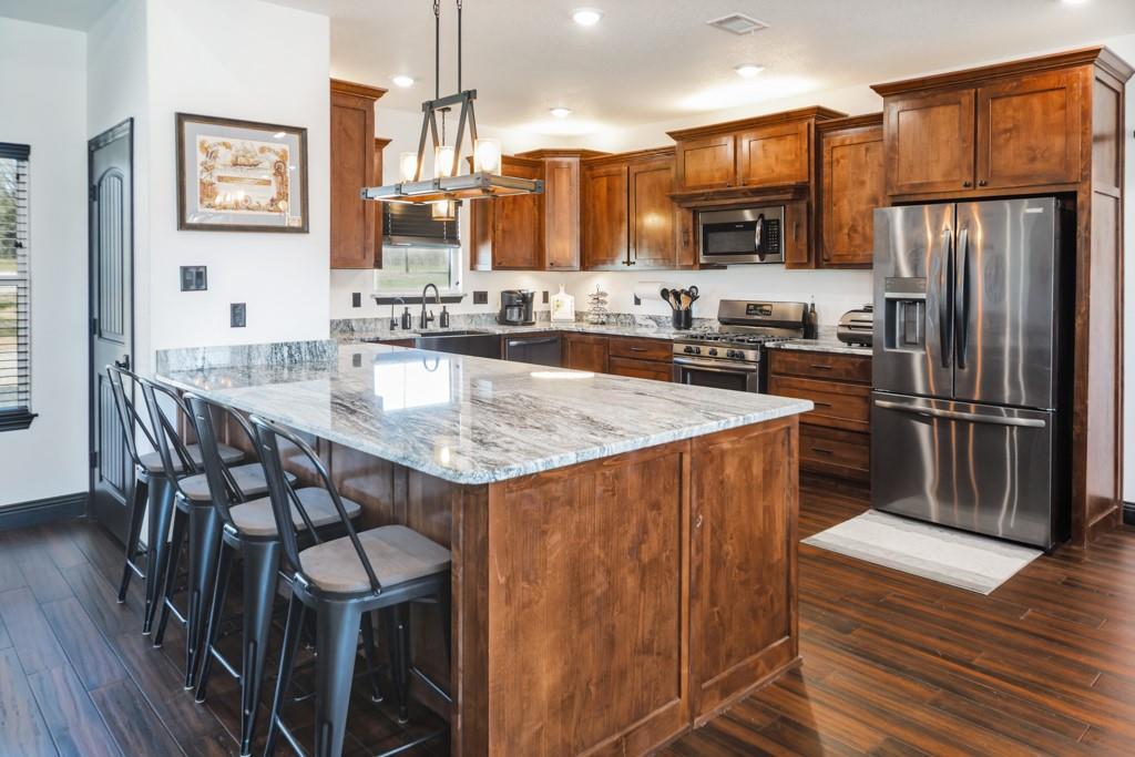 217 Polk Road Bowie, TX 76230 - Photo 2 of 39 a kitchen with stainless steel appliances granite countertop a kitchen island a stove a refrigerator a sink and a refrigerator