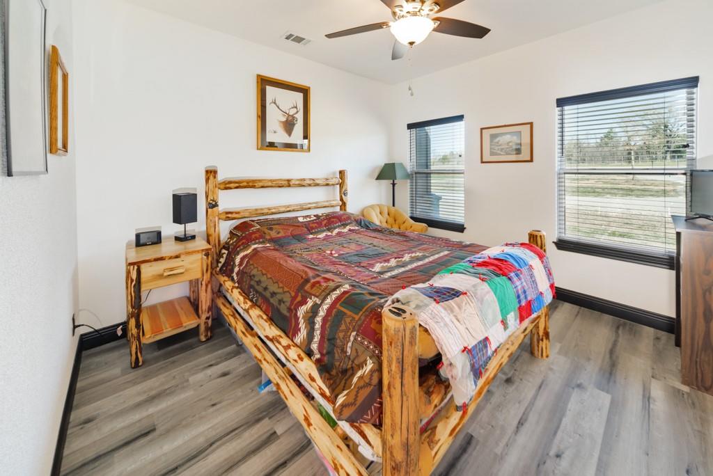 217 Polk Road Bowie, TX 76230 - Photo 21 of 39 a bedroom with a bed and a chandelier