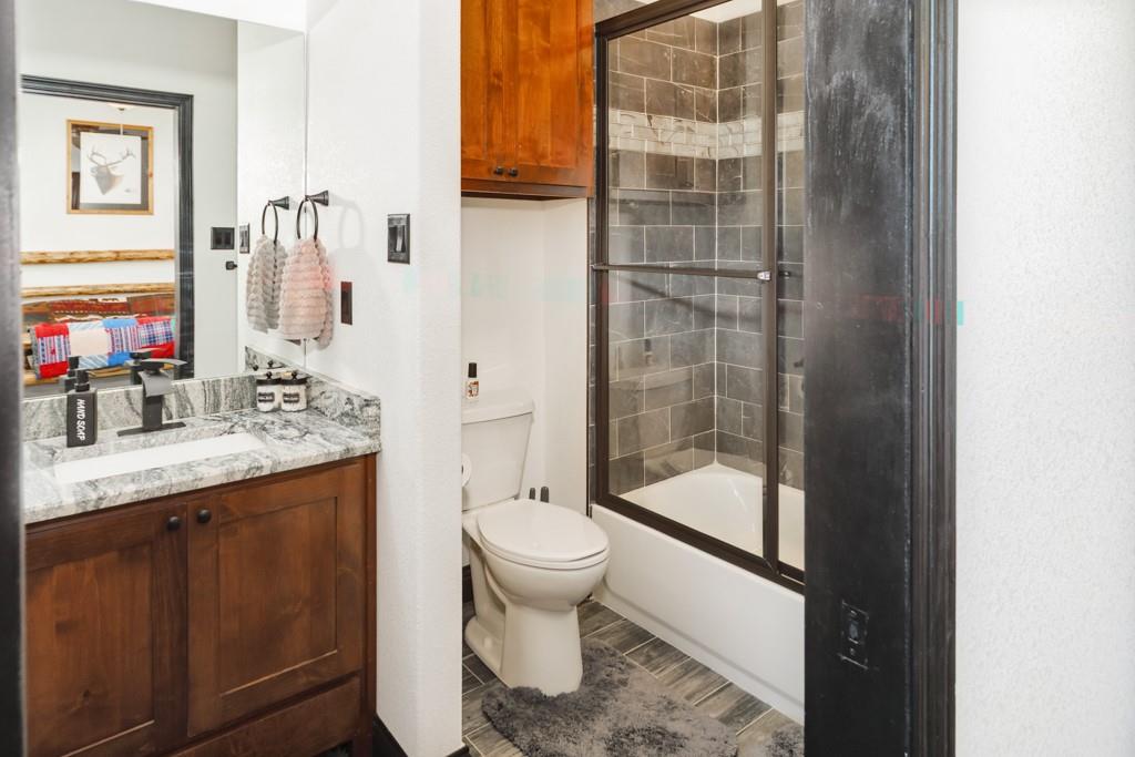 217 Polk Road Bowie, TX 76230 - Photo 22 of 39 a bathroom with a granite countertop sink toilet and shower