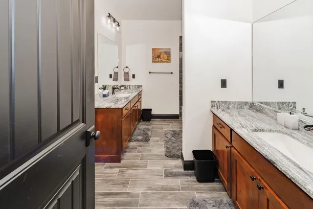 a bathroom with a granite countertop sink a toilet and shower