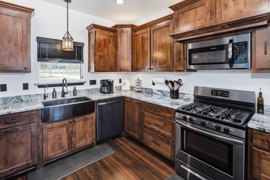 217 Polk Road Bowie, TX 76230 - Photo 5 of 39 a kitchen with stainless steel appliances wooden cabinets and a stove top oven