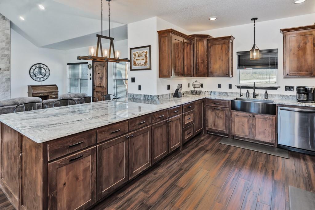 217 Polk Road Bowie, TX 76230 - Photo 6 of 39 a kitchen with stainless steel appliances granite countertop a sink a stove and a wooden floors
