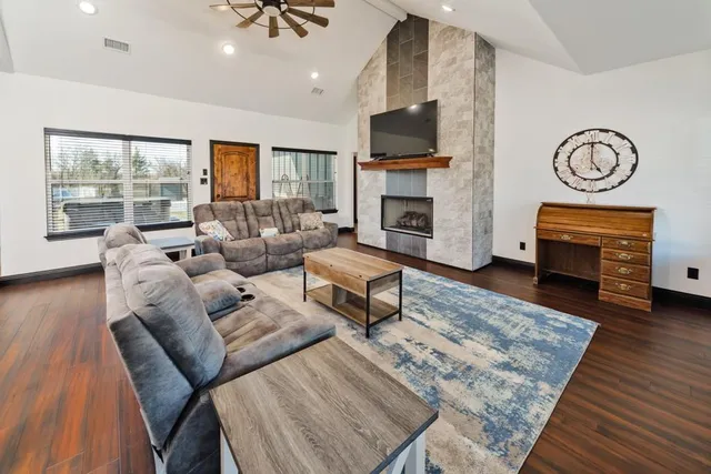 a living room with furniture a fireplace and a flat screen tv