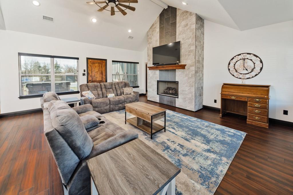 217 Polk Road Bowie, TX 76230 - Photo 10 of 39 a living room with furniture a fireplace and a flat screen tv
