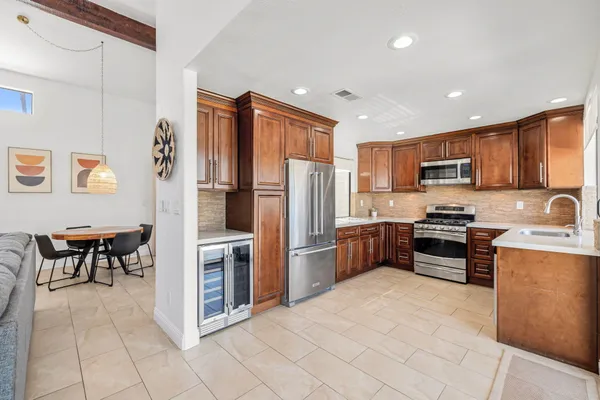 a kitchen with granite countertop a refrigerator and a stove top oven