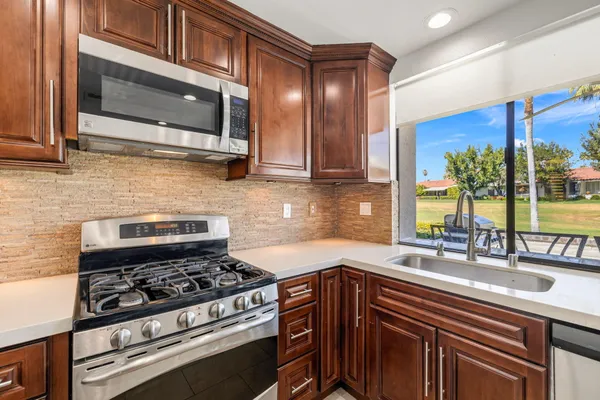 a kitchen with stainless steel appliances a stove a sink and a microwave