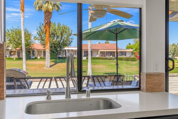 a view of swimming pool with a table and chairs under an umbrella