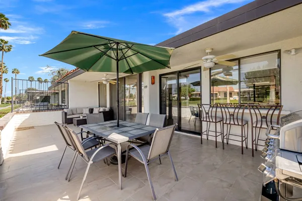 a view of a swimming pool with a table and chairs under an umbrella