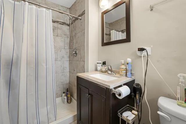 a bathroom with a sink a toilet and shower