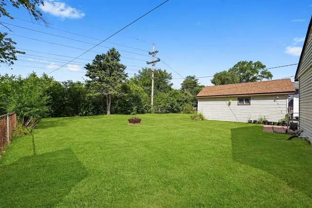 a backyard of a house with plants and wooden fence