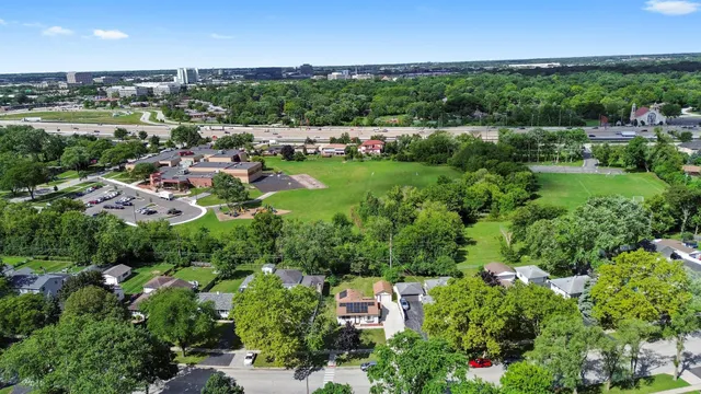 an aerial view of green landscape with trees houses and mountain view