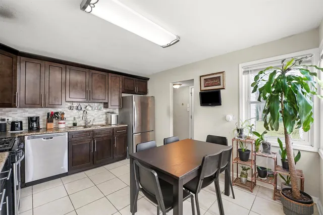 a kitchen with stainless steel appliances a stove top oven a refrigerator a sink and a stove