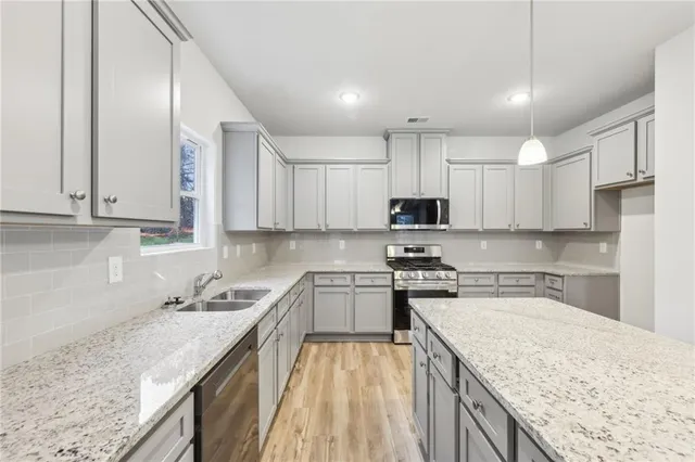 a kitchen with kitchen island granite countertop a sink stove top oven and cabinets