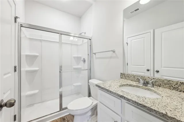 a bathroom with a granite countertop sink toilet and shower