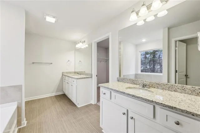 a bathroom with a granite countertop sink a large mirror and a shower