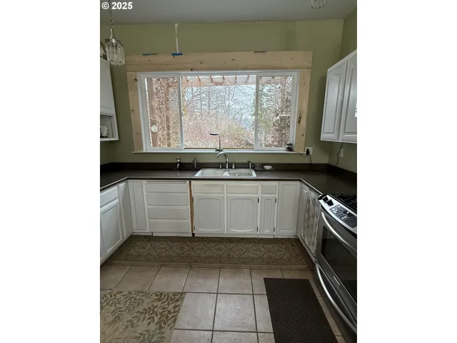 a kitchen with a sink window and cabinets