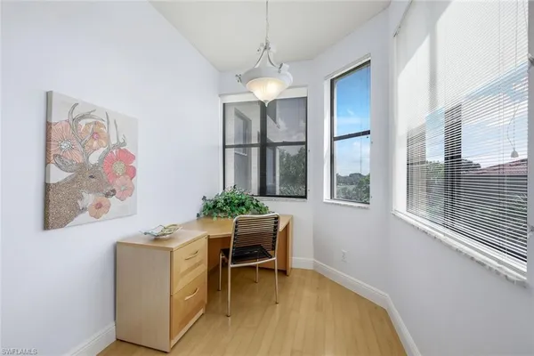 a view of a workspace with furniture and a window