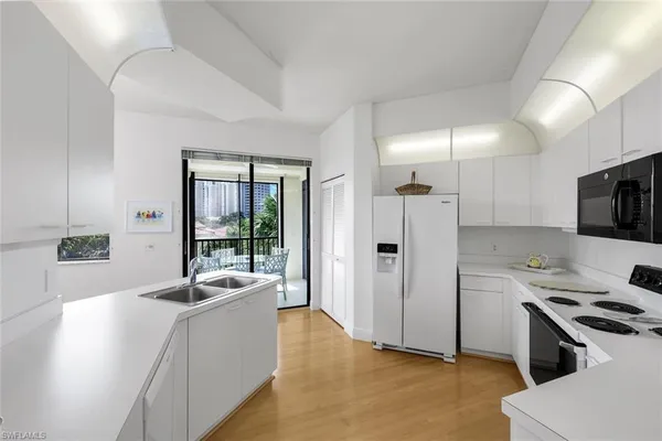 a large white kitchen with a stove a sink and a refrigerator