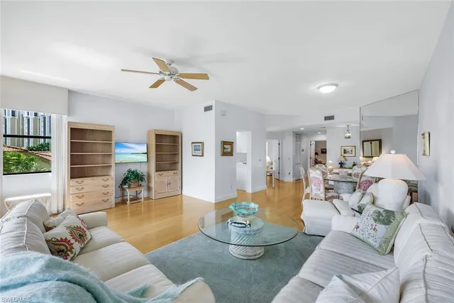 a living room with furniture kitchen view and a large window