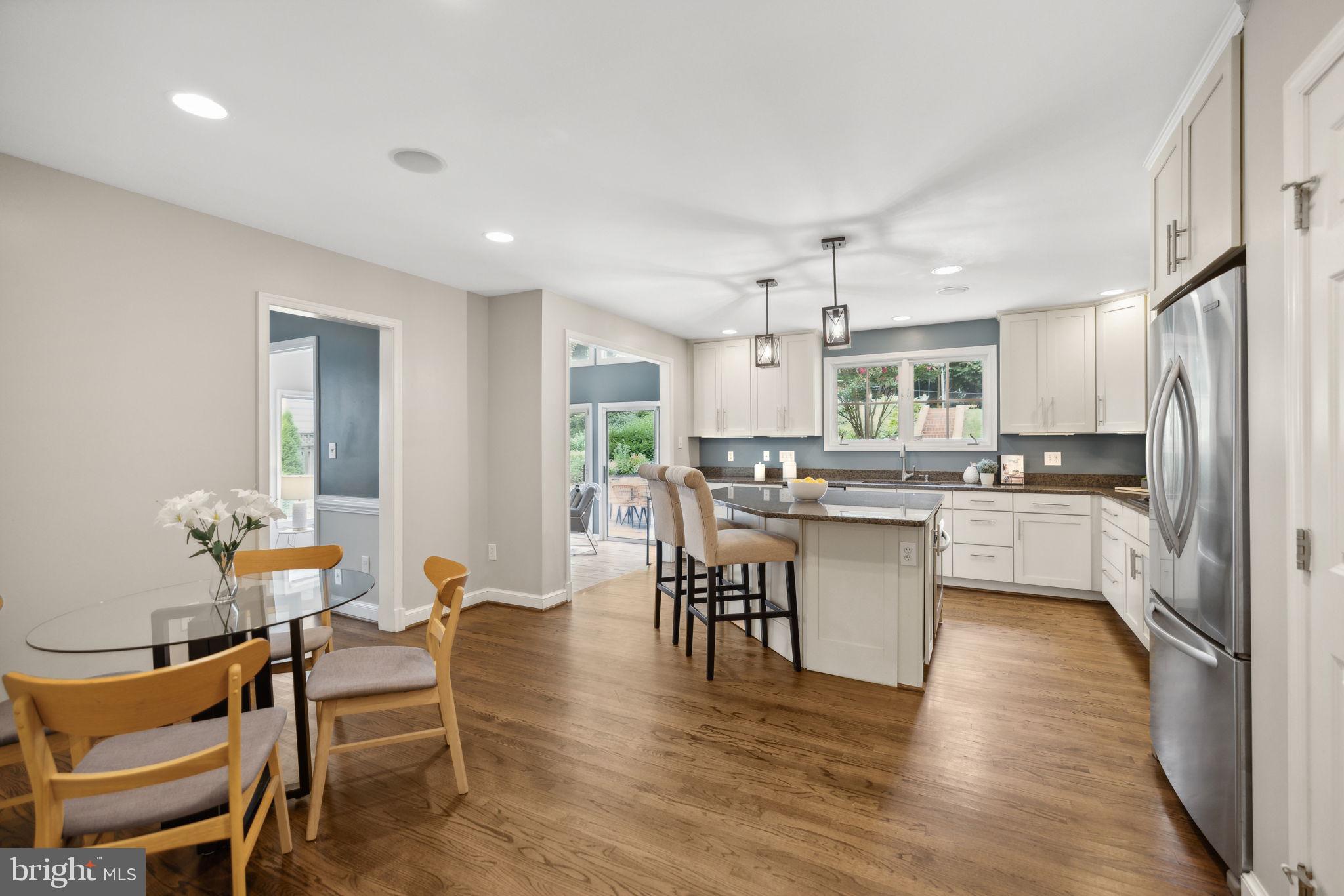 8012 Beech Tree Road Bethesda, MD 20817 - Photo 8 of 25 a kitchen with a table chairs refrigerator and cabinets