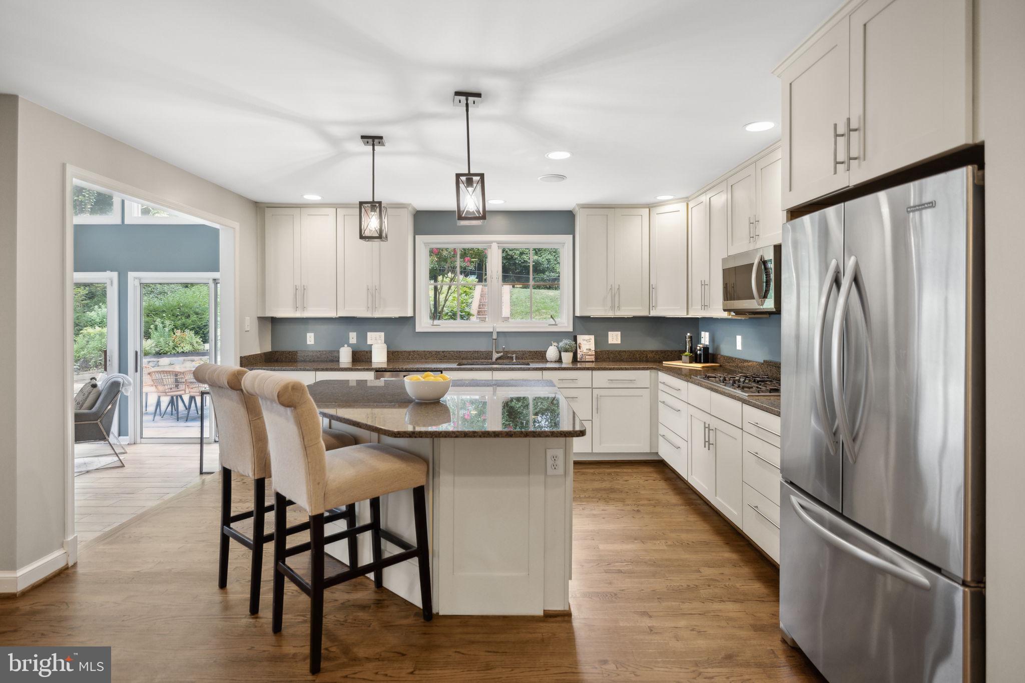 8012 Beech Tree Road Bethesda, MD 20817 - Photo 9 of 25 a kitchen with stainless steel appliances a refrigerator a sink a center island and a window