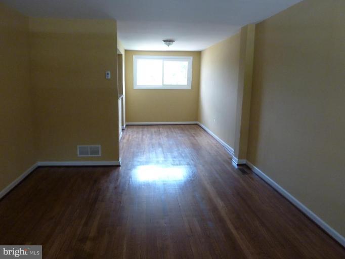 4805 Greencrest Road Baltimore, MD 21206 - Photo 3 of 10 an empty room with wooden floor and windows