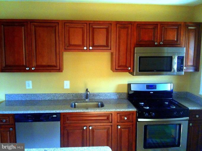 4805 Greencrest Road Baltimore, MD 21206 - Photo 8 of 10 a kitchen with stainless steel appliances a stove and a microwave