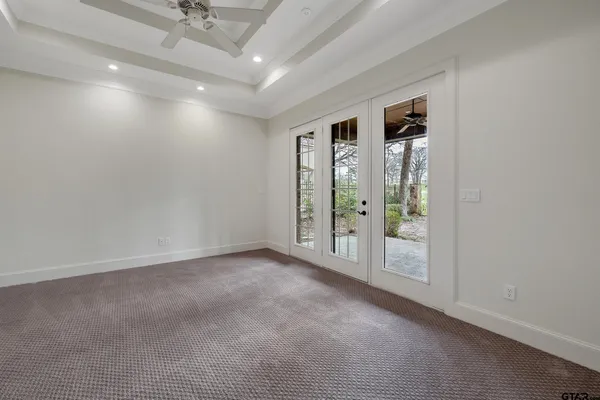 en empty room with windows and ceiling fan