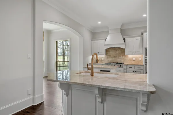 a kitchen with granite countertop a stove a sink and a refrigerator