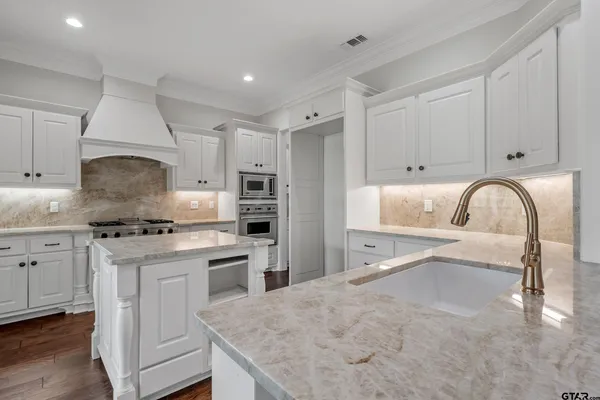 a kitchen with granite countertop a sink and a stove with kitchen countertops