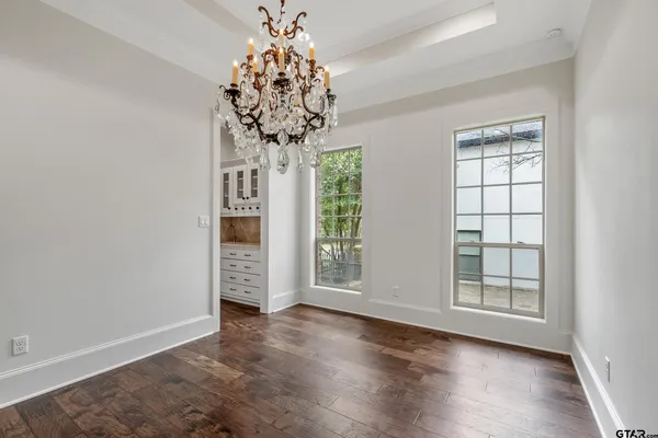a view of a room with wooden floor chandelier and window