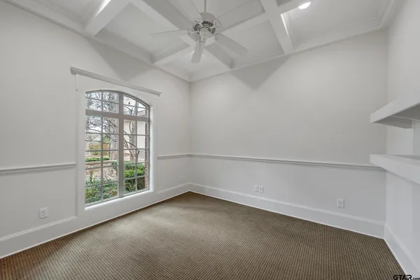 an empty room with a window and a ceiling fan