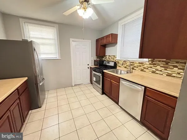 a kitchen with a sink a stove top oven and cabinetry