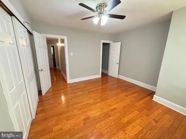 an empty room with wooden floor and entrance