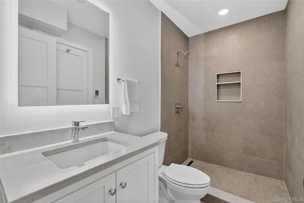 a bathroom with a granite countertop sink a toilet and shower