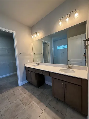 a bathroom with a double vanity sink a mirror and a bathtub