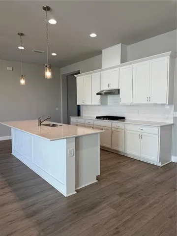 a kitchen with kitchen island sink stove and cabinets