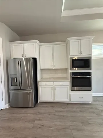 a kitchen with granite countertop a refrigerator and a stove top oven