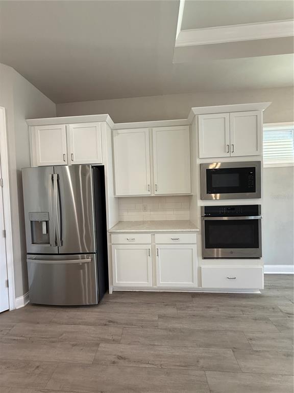 11822 Southwest 34th Road Gainesville, FL 32608 - Photo 9 of 24 a kitchen with granite countertop a refrigerator and a stove top oven