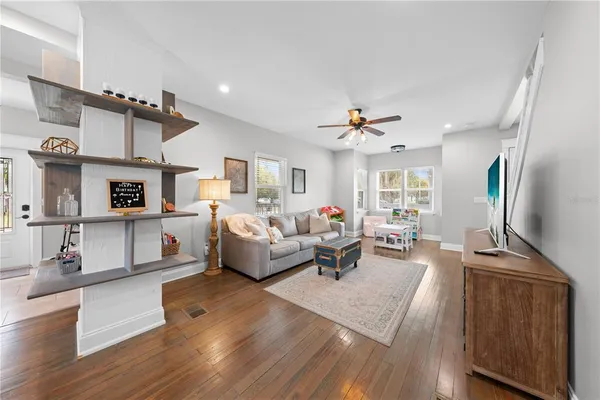 a living room with furniture or chandelier and a wooden floor