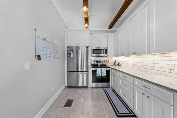 a kitchen with white cabinets and stainless steel appliances