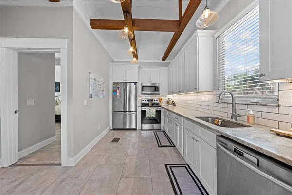 a kitchen with stainless steel appliances granite countertop a sink and a refrigerator