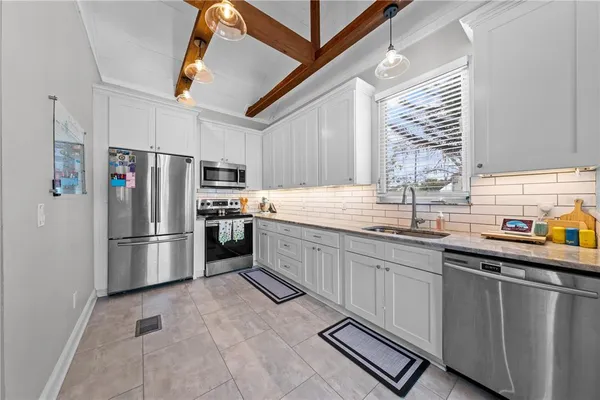 a kitchen with stainless steel appliances a refrigerator sink and cabinets