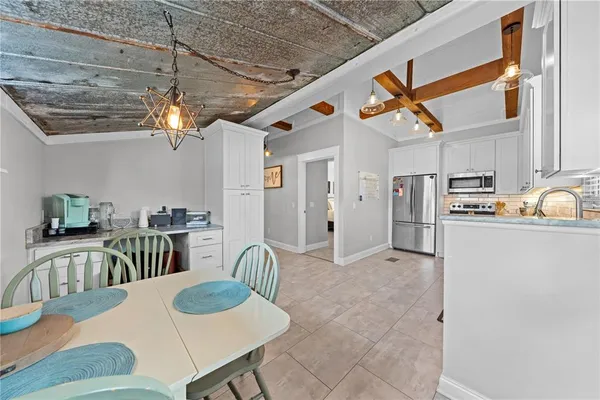 a kitchen with stainless steel appliances granite countertop a dining table chairs sink and granite counter tops