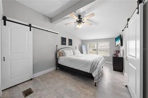a spacious bedroom with a bed and cabinet