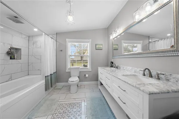 a bathroom with a granite countertop sink toilet and bathtub